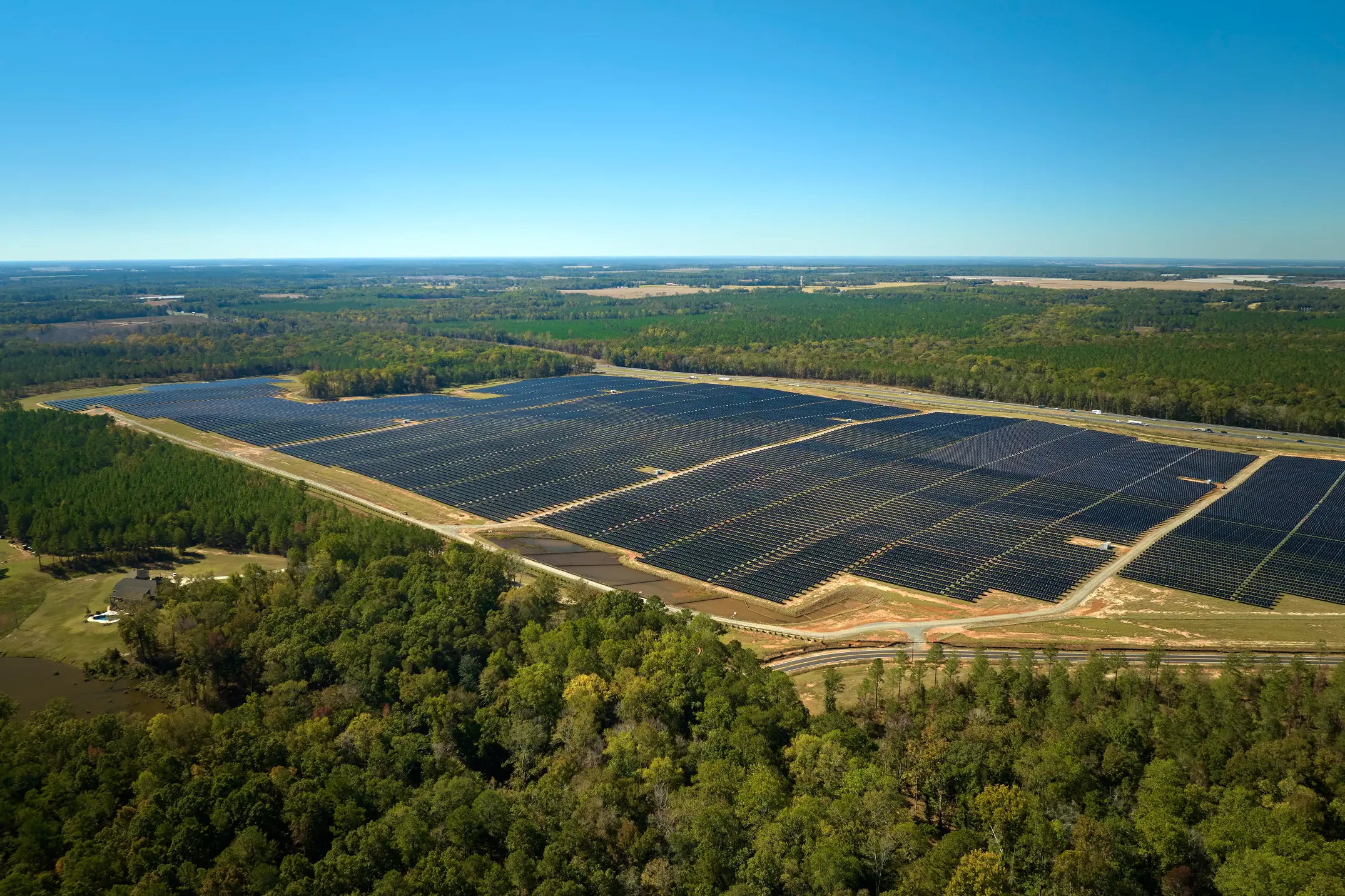 aerial-view-big-sustainable-electric-power-plant-with-many-rows-solar-photovoltaic-panels-producing-clean-electrical-energy-renewable-electricity-with-zero-emission-concept (1)